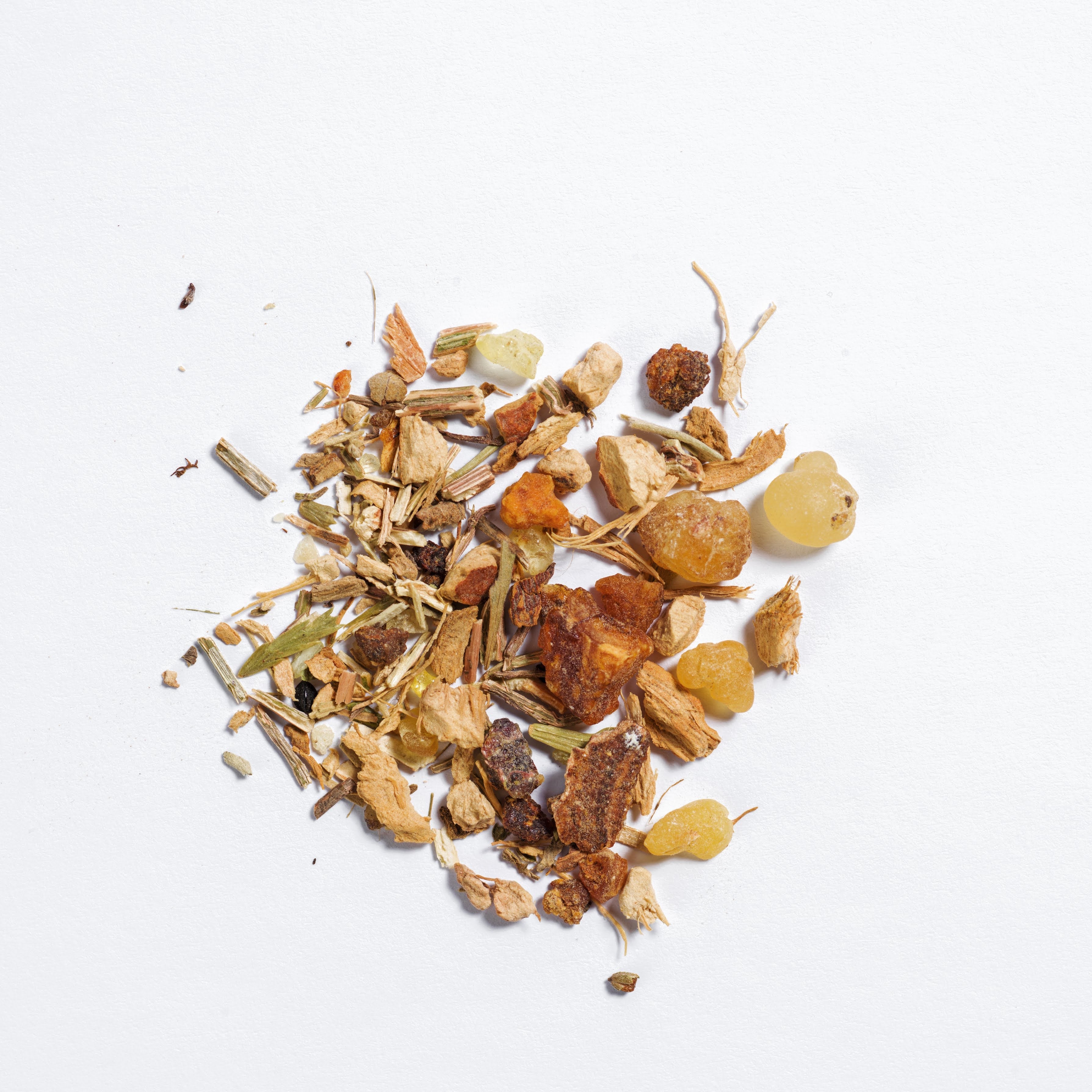 Manifestation Räuchermischung liegt auf einem weißen Hintergrund. Man sieht die einzelnen kleinen Räucher-Rituals Zutaten wie Weihrauch, Salbei und co.