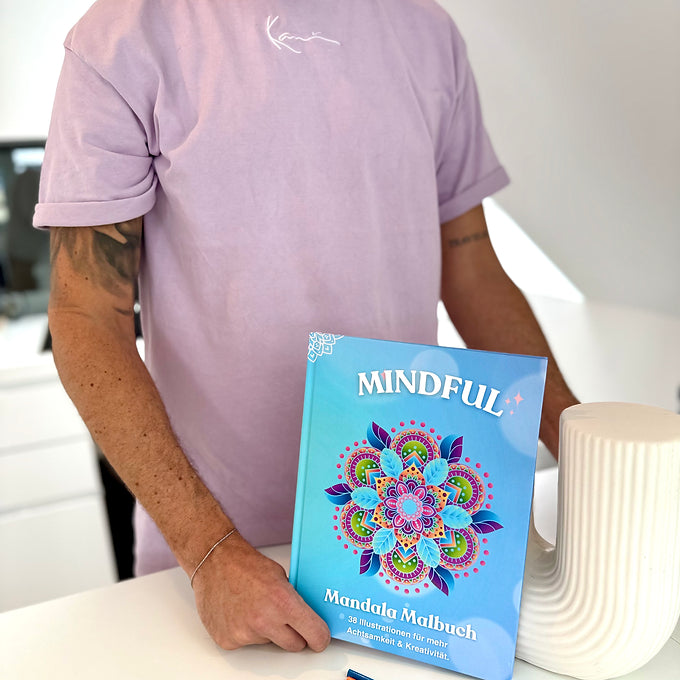 Man hält das Mindful Mandala Malbuch