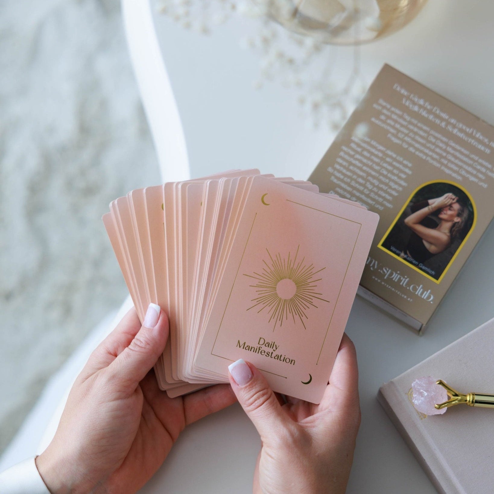 Daily Manifestation Karten in zartem Rosé, gehalten in den Händen