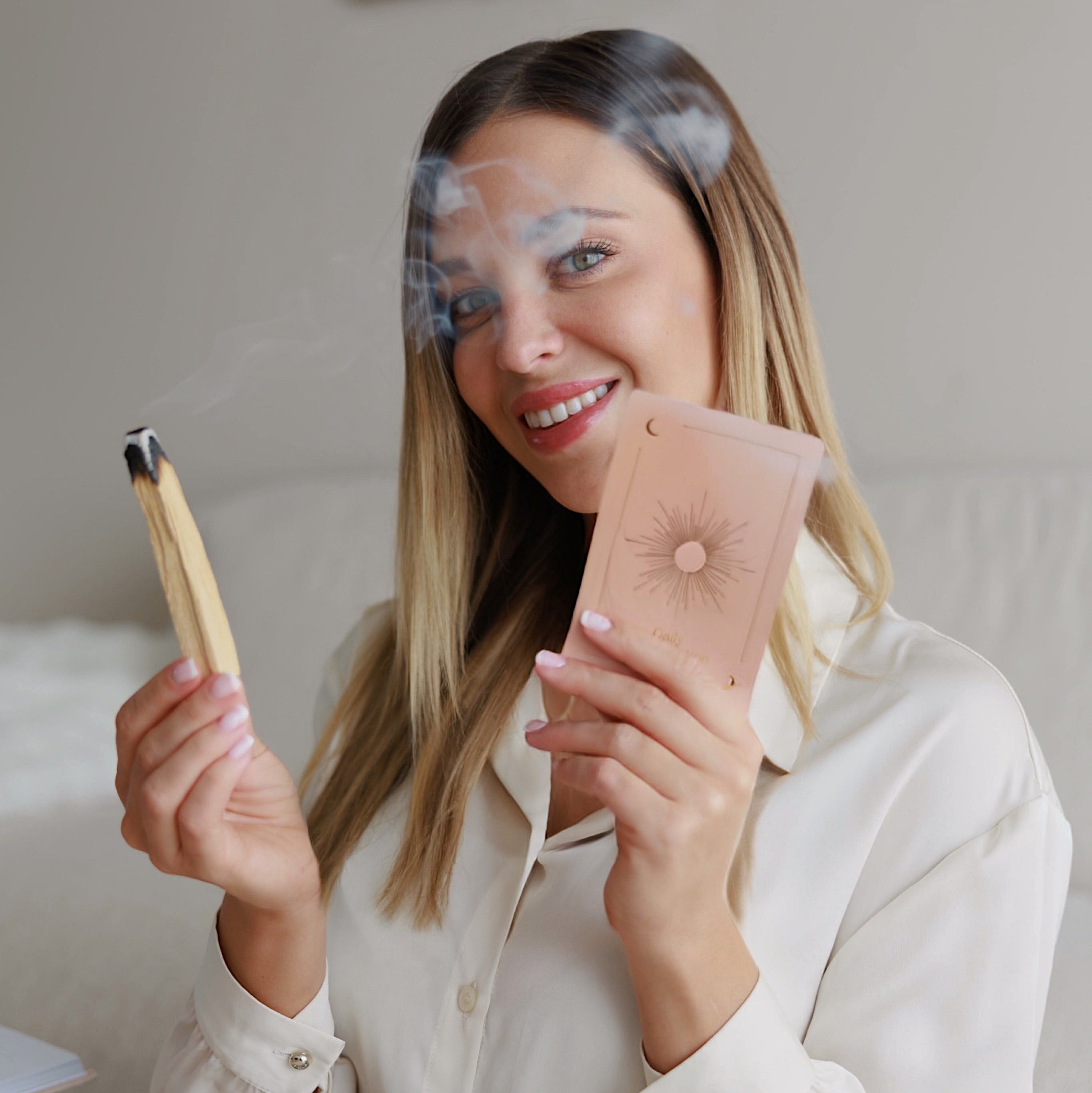Frau hält Daily Manifestation Karten und Palo Santo in der Hand - achtsames Ritual für positive Gedanken