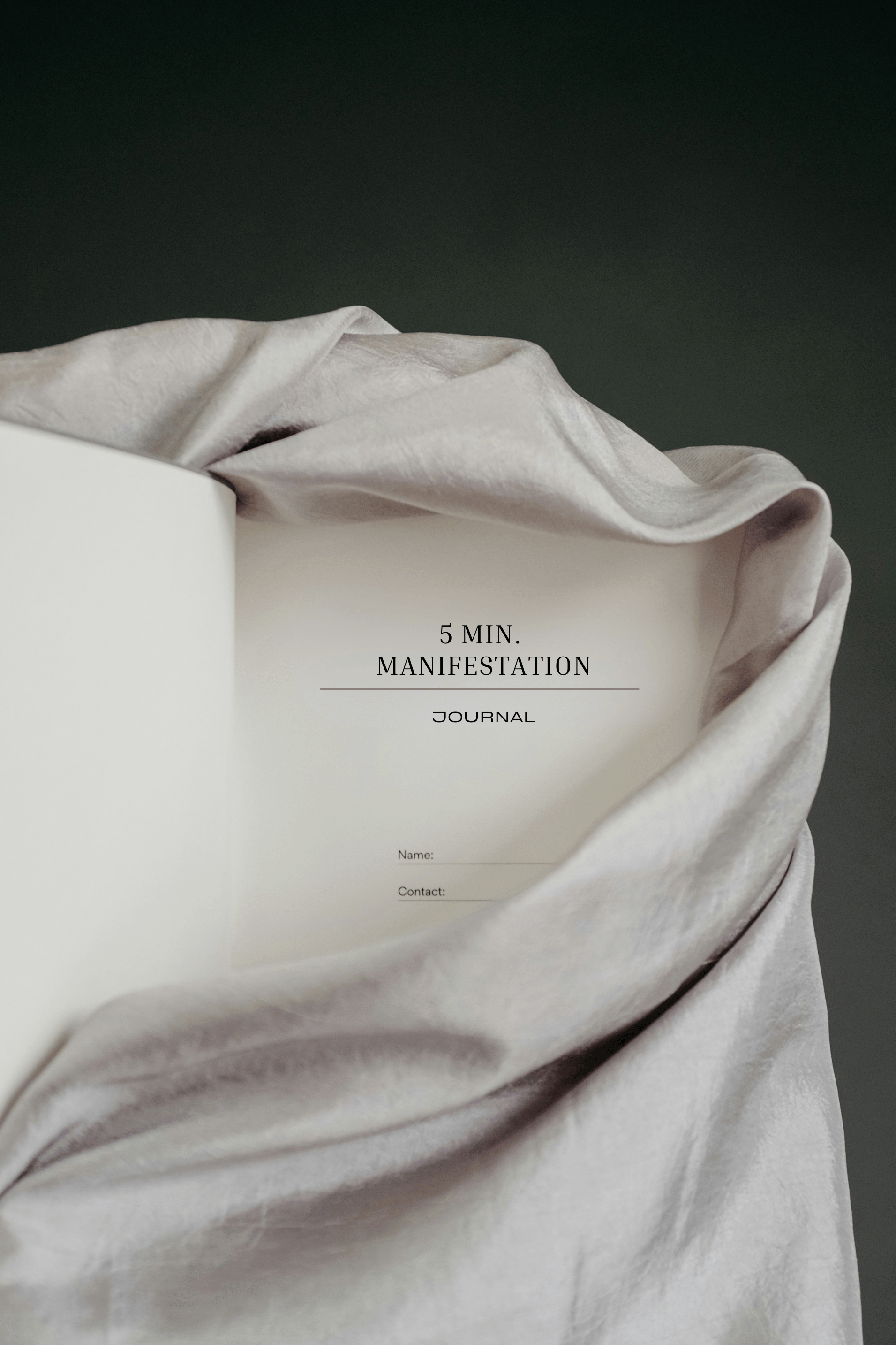 Aufgeschlagenes 5 Minuten Manifestation Journal in weichem Stoff drapiert für ein ruhiges Schreibritual