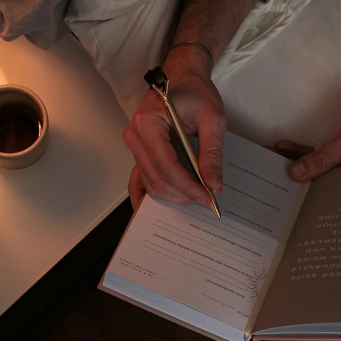Mann schreibt am Abend in sein 5 Minuten Manifestation Journal 