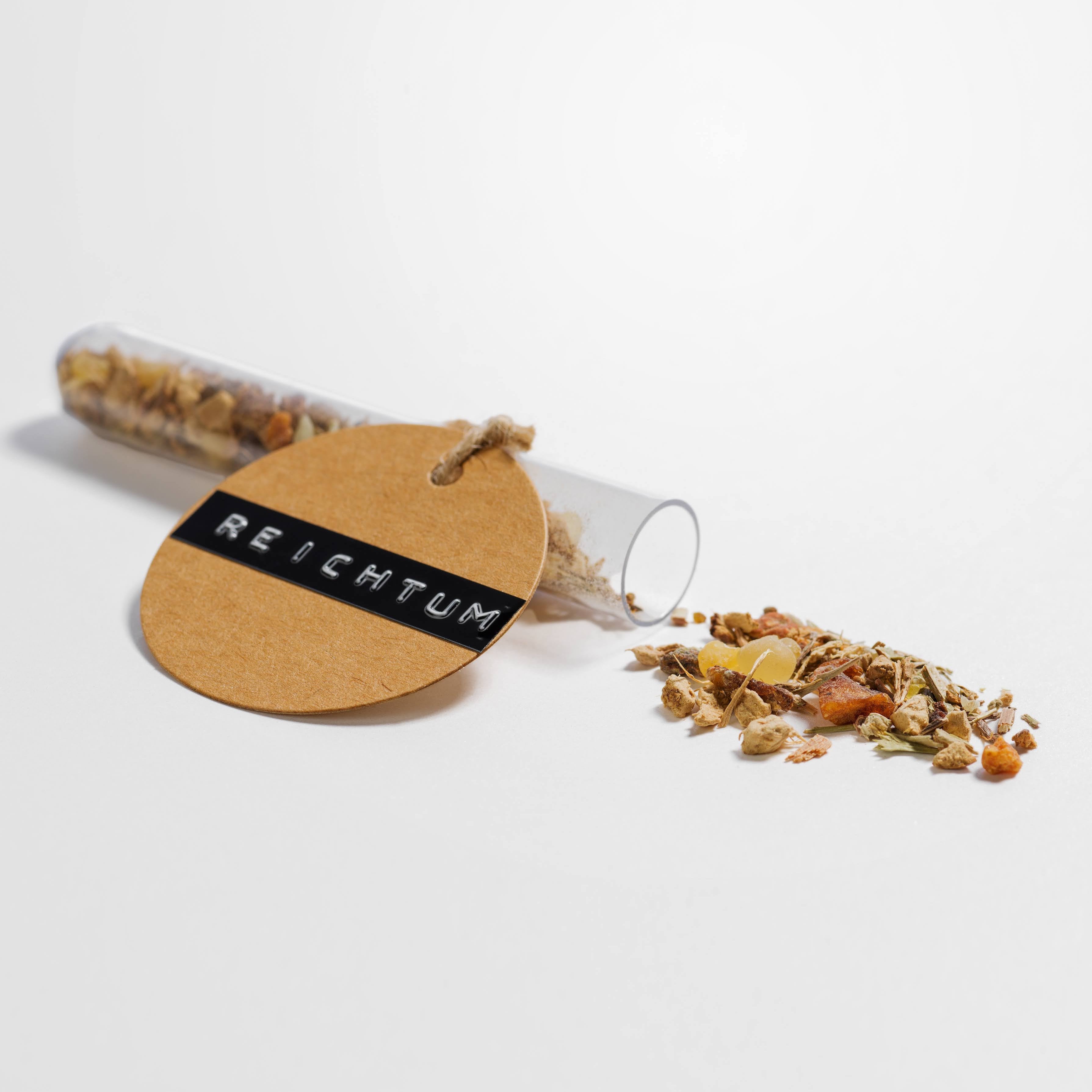 Reichtum Manifestation Räuchermischung liegt auf einem weißen Hintergrund. Man sieht die einzelnen kleinen Räucher-Ritual Zutaten wie Weihrauch und co.