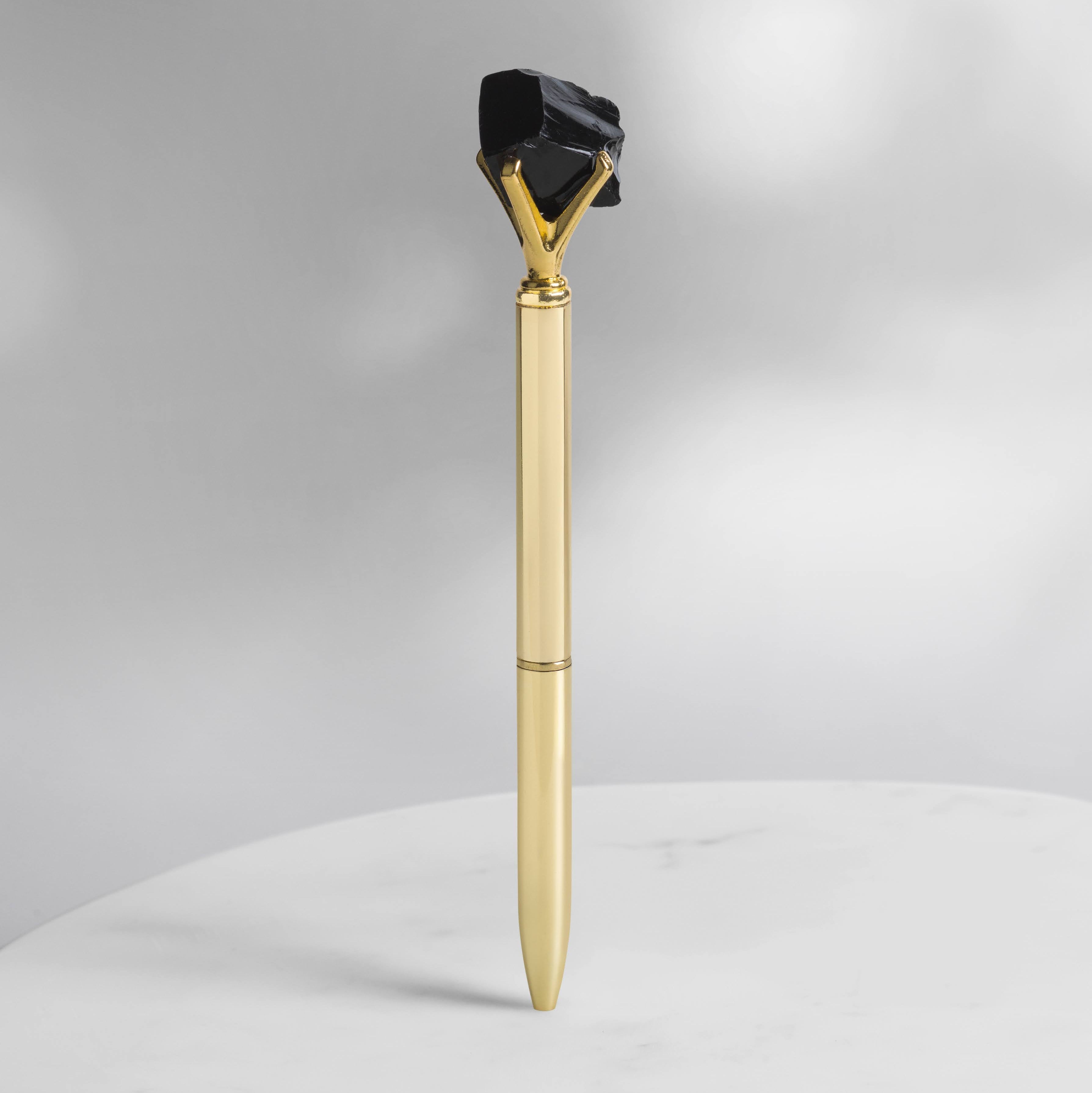 Schwarzer Obsidian Kristallstift in Goldoptik mit rohem Obsidian, Schutz- und Erdungskristall für Journaling, Manifestation und tägliche Rituale auf hellem Hintergrund.